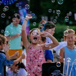 Дети смеются, играя с пузырями