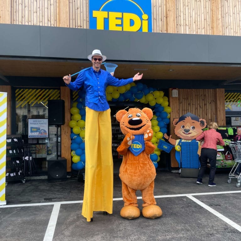 Stelzenläufer Michael Altmann und TEDi-Maskottchen vor dem neuen TEDi-Shop in Eggelsberg