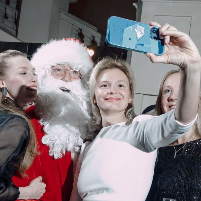Trendiger Weihnachtsmann Egor Hahuleac macht Selfies mit Gästen auf einer Firmenfeier