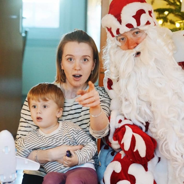 Egor Hahuleac als Weihnachtsmann bei einem Hausbesuch mit Mutter und Kind