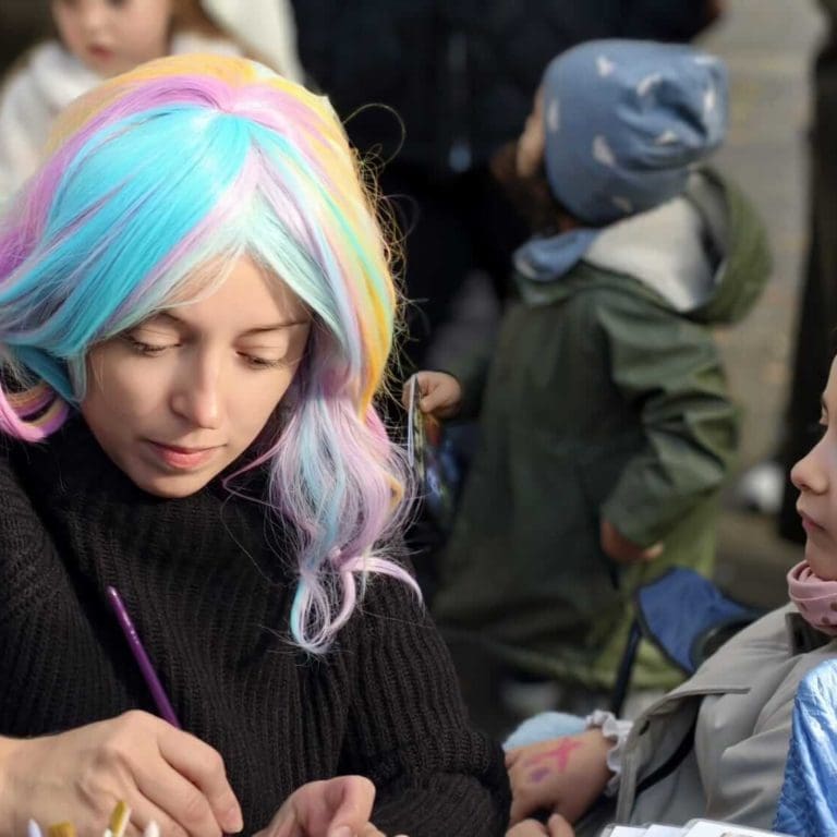 Vera Hahuleac preparing face paints at a human rights event in Vienna